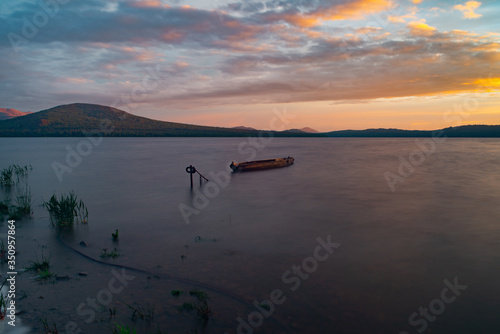 The view of the sunset and boats on the lake Zuratkul