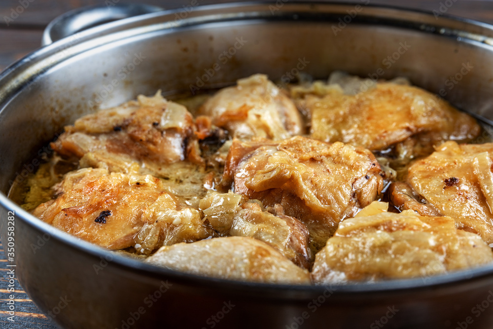 Appetizing tasty fried chicken thighs in a pan, close-up, shallow depth of field, selective focus. Homemade food concept. Appetizing tasty fried chicken thighs in a pan, close-up, shallow depth of field, selective focus. Homemade food concept.