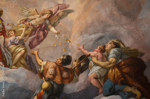 Painting of angel dropping coins to followers on the domed ceiling of Charles Church in Vienna, Austria.