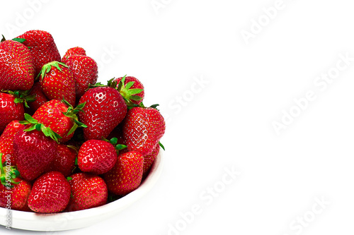 Ripe strawberries in white bowl on white background Copy space