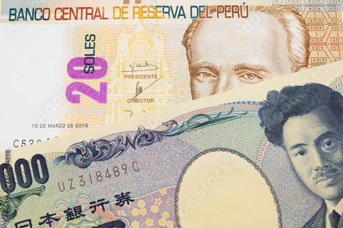 A macro image of a Japanese thousand yen note paired up with a beige, twenty sol bill from Peru. Shot close up in macro.