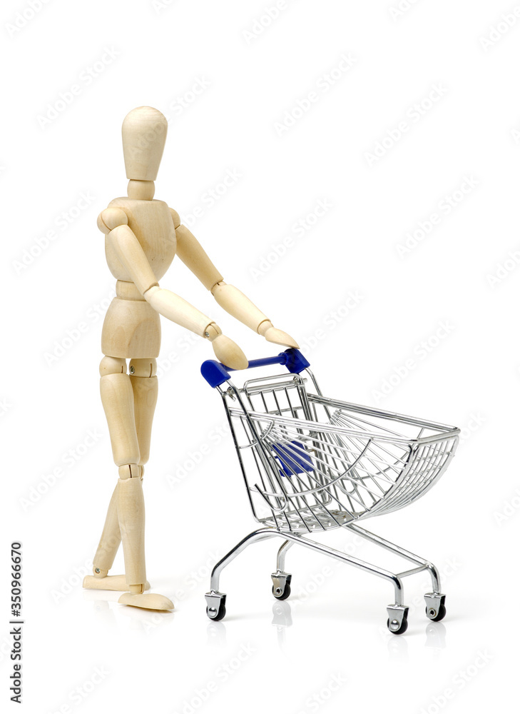 Shopping concept. Wooden doll and metal shopping cart Shopping concept. Wooden doll and metal shopping cart