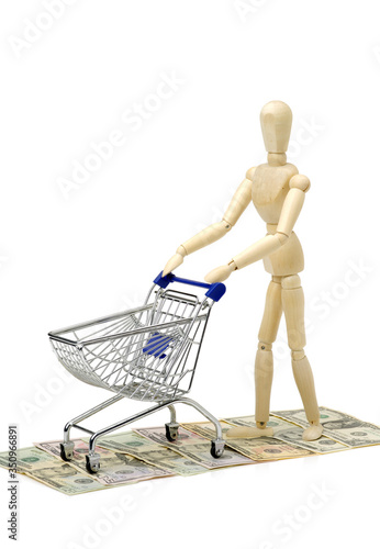 Shopping concept. Wooden doll and metal shopping cart © zcy