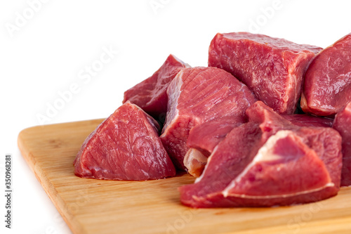 Chopped raw meat on wooden board isolated on white background