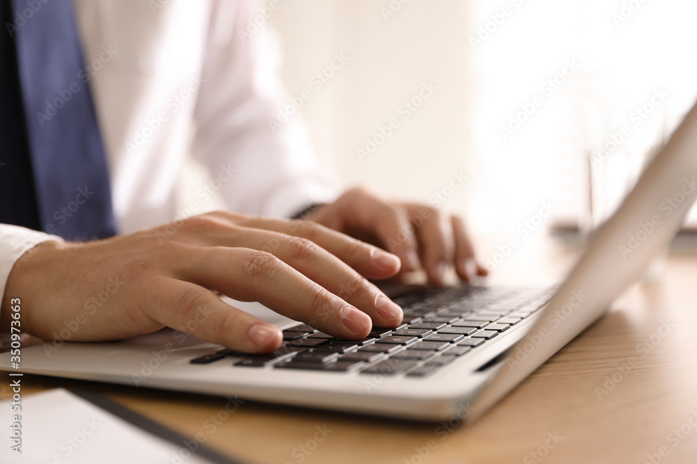 Man working with laptop in office, closeup of hands Man working with laptop in office, closeup of hands