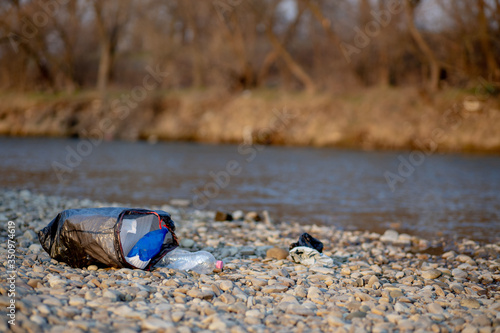 Garbage near the river. Environmental pollution shore © volody10