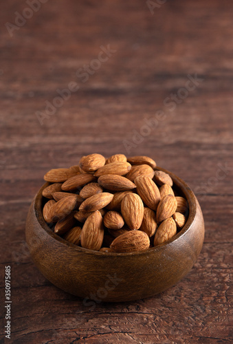 Bowl Full of Raw Natural Almonds on a Dark Wood Table