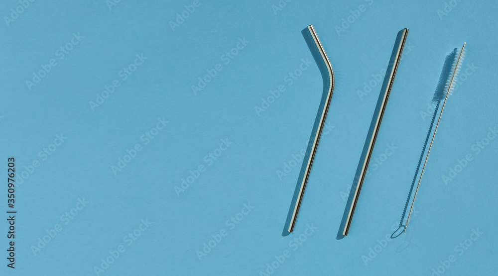 A set of reusable accessories for drinks. A set of steel straws and a cleaning brush. Blue background, top view. The zero waste concept. Copy space. A set of reusable accessories for drinks. A set of steel straws and a cleaning brush. Blue background, top view. The zero waste concept. Copy space.
