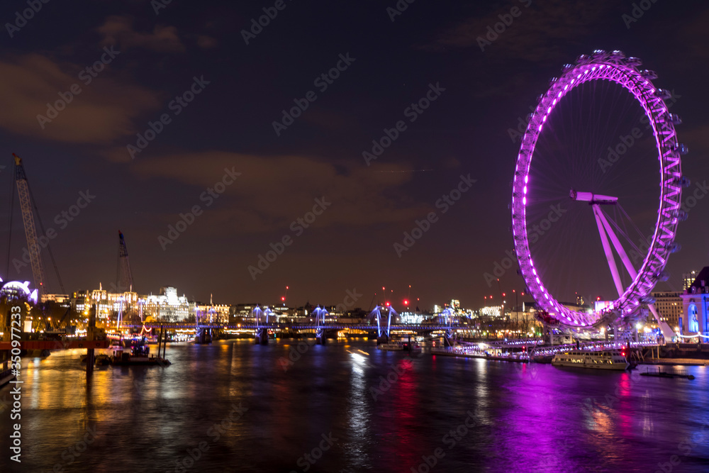 Night photo of London with illuminated London Eye and Thames