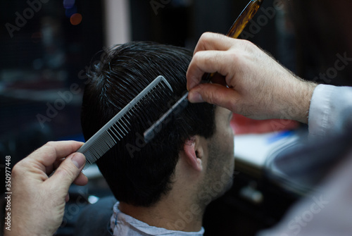 Handsome man taking haircut at the barbershop 