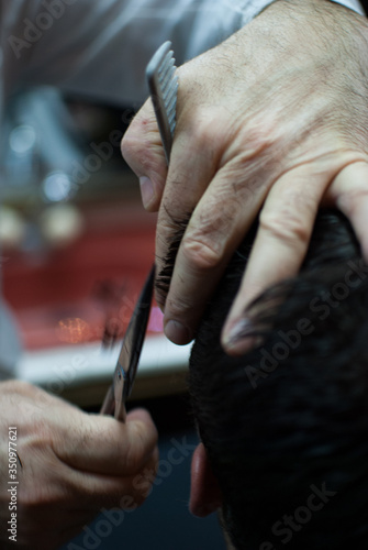 Closeup of barber hands cutting hair