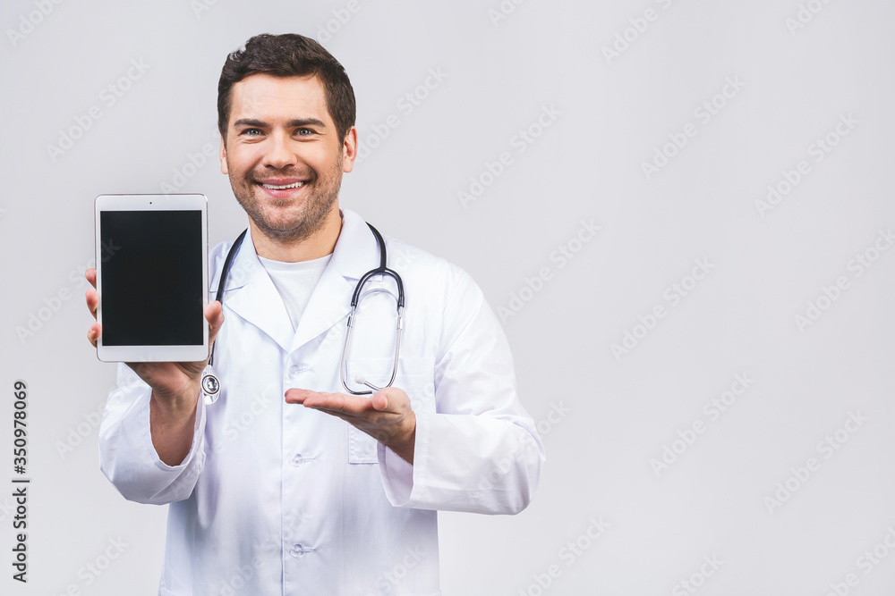 Portrait of friendly doctor presenting empty digital tablet screen. Isolated on white background. Portrait of friendly doctor presenting empty digital tablet screen. Isolated on white background.
