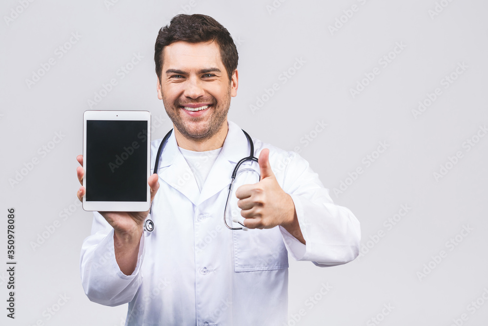 Portrait of friendly doctor presenting empty digital tablet screen. Isolated on white background. Thumbs up. Portrait of friendly doctor presenting empty digital tablet screen. Isolated on white background. Thumbs up.