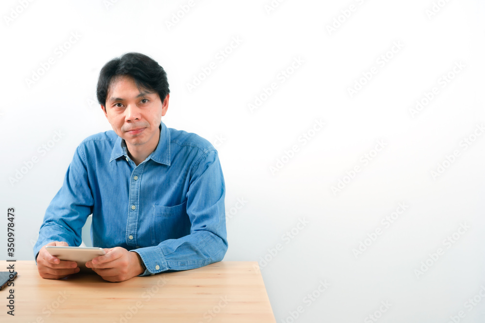 asian business man 30s to 40s with blue shirt use tablet for check profit of his startup business with white isolated background asian business man 30s to 40s with blue shirt use tablet for check profit of his startup business with white isolated background