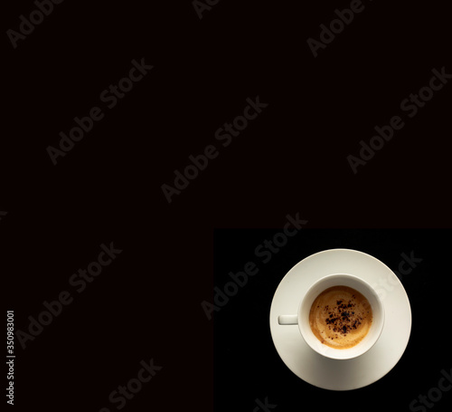top view of white cup of coffee on a dark black background.