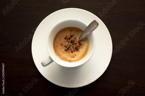 Fototapeta Naklejka Na Ścianę i Meble -  top view of white cup of coffee on a dark black background.