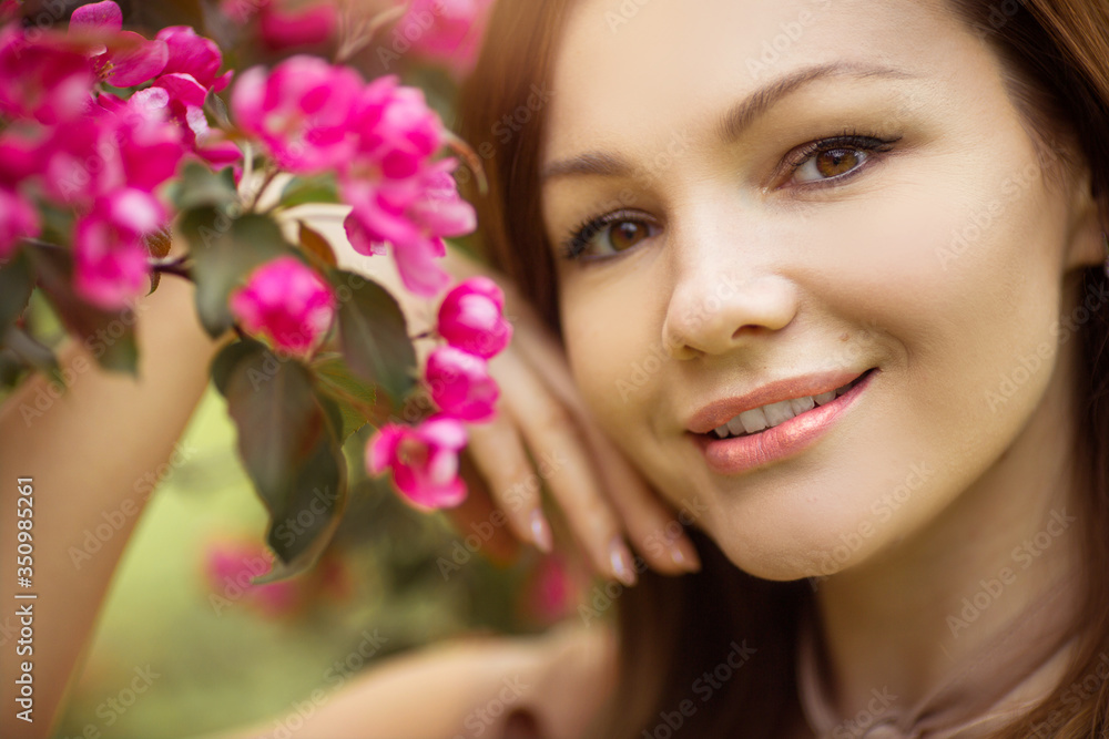 portrait of a beautiful young woman with make-up near a tree with flowers portrait of a beautiful young woman with make-up near a tree with flowers