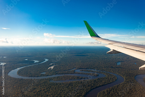 Flying over the Amazonas river, airplane wing.