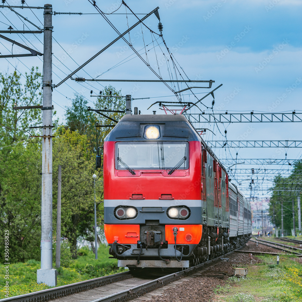 Passenger train moves from the station at evening time.. Passenger train moves from the station at evening time..