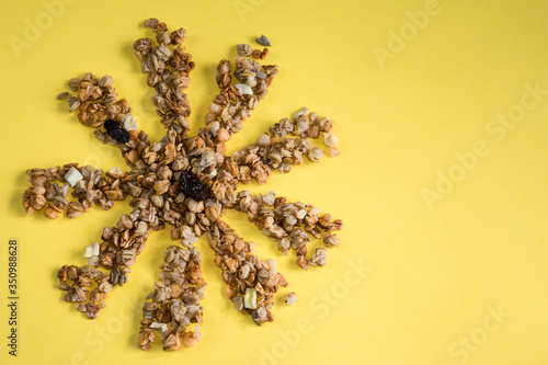 muesli fried in the sun dried fruits raisins on a yellow background place for text