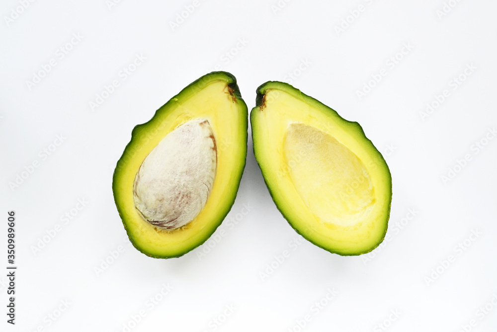 Halved avocado with bone isolated on white background. View from above