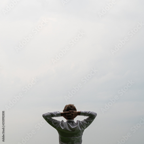 Fotografia Businessman standing under cloudy sky