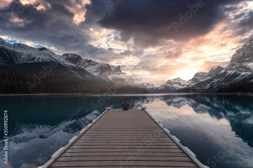 Man traveler enjoying the view of Spirit Island in Maligne Lake at Jasper National Park