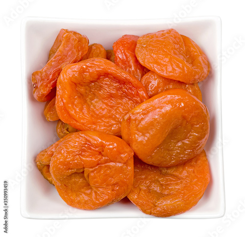 Isolated dried apricots. Bowl of dried apricots isolated on white background with clipping path. Top view.