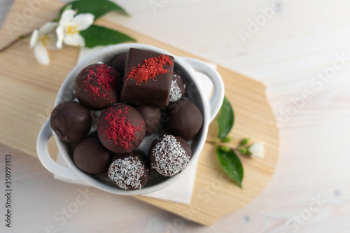 Chocolate candies assorted on a white background with red rose