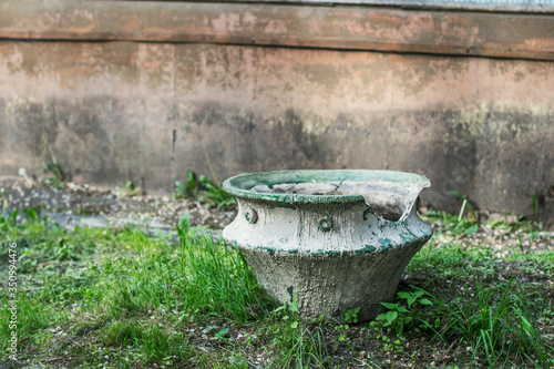 An old broken flower pot in a city Park on a summer day. © OlPhoto