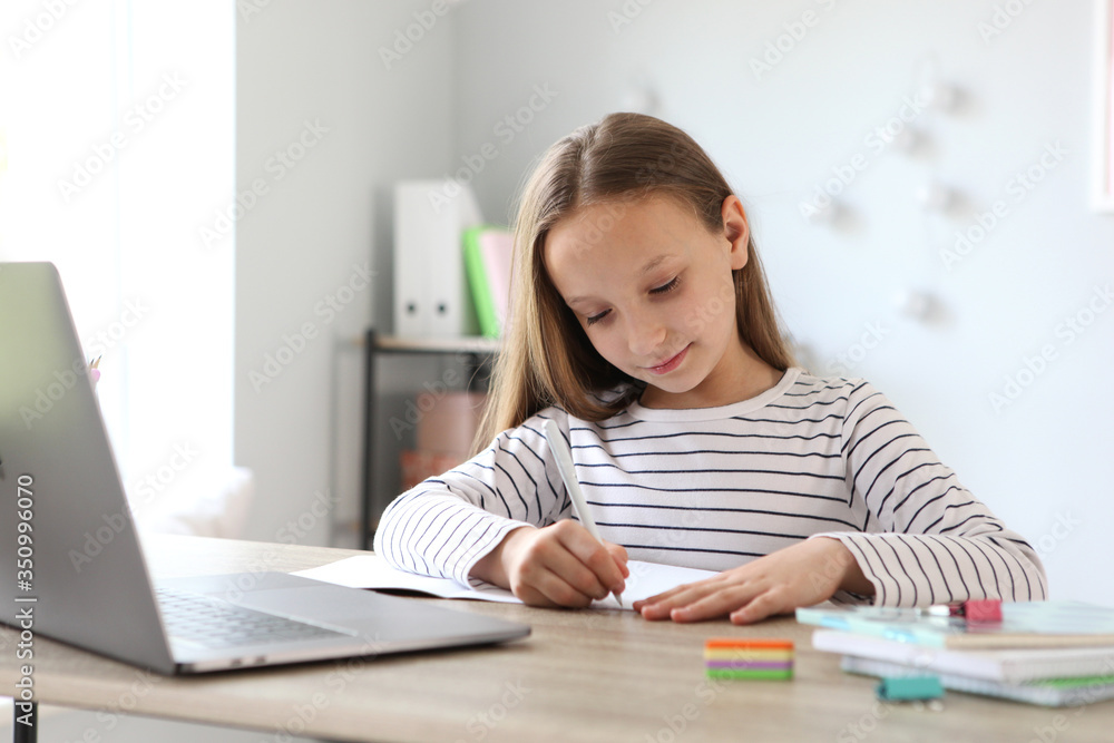 A child learns online at home through a modern laptop on the Internet.
A child learns online at home through a modern laptop on the Internet.