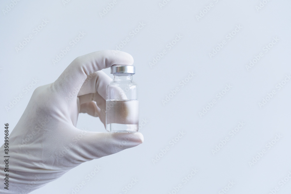 Medical staff in PPE suit holding syringes and vaccines for the treatment of the COVID-19 virus. Medical researchers in the lab are testing vaccines for the treatment of viral diseases. Medical staff in PPE suit holding syringes and vaccines for the treatment of the COVID-19 virus. Medical researchers in the lab are testing vaccines for the treatment of viral diseases.