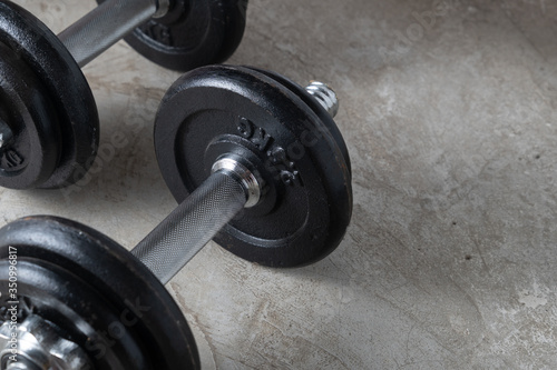 Dumbbells for muscle building exercise placed on cement floor with copyspace.Body workout in the gym training concept.new normal popular lifestyles for strong and healthy bodybuilding at home