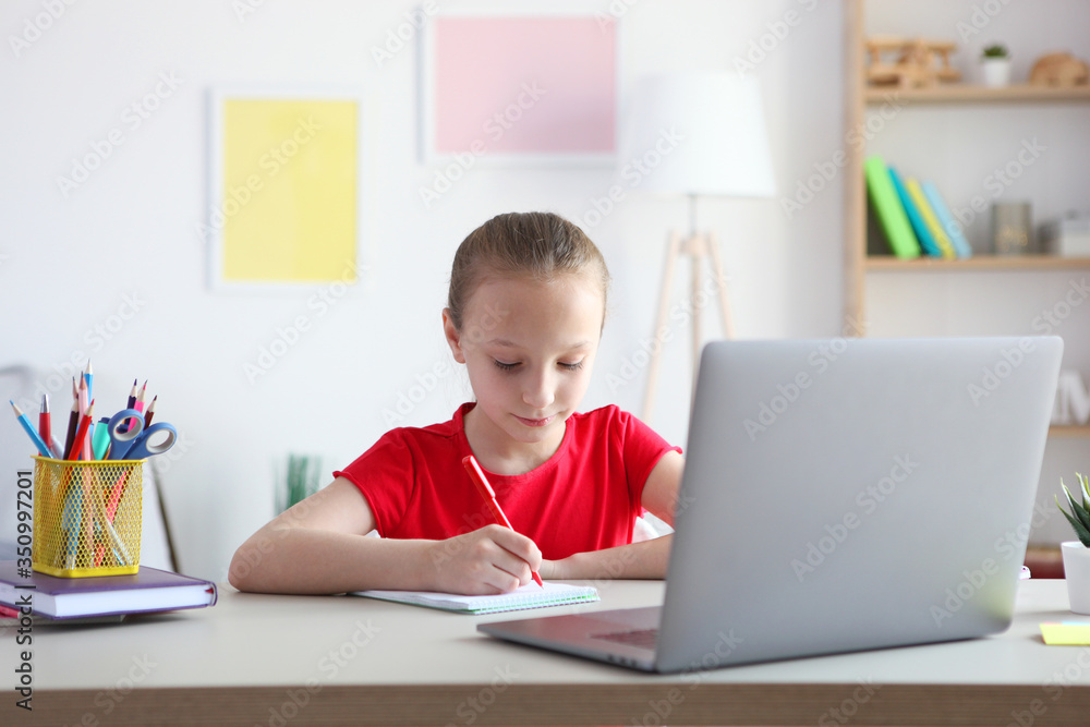 A child learns online at home through a modern laptop on the Internet.
