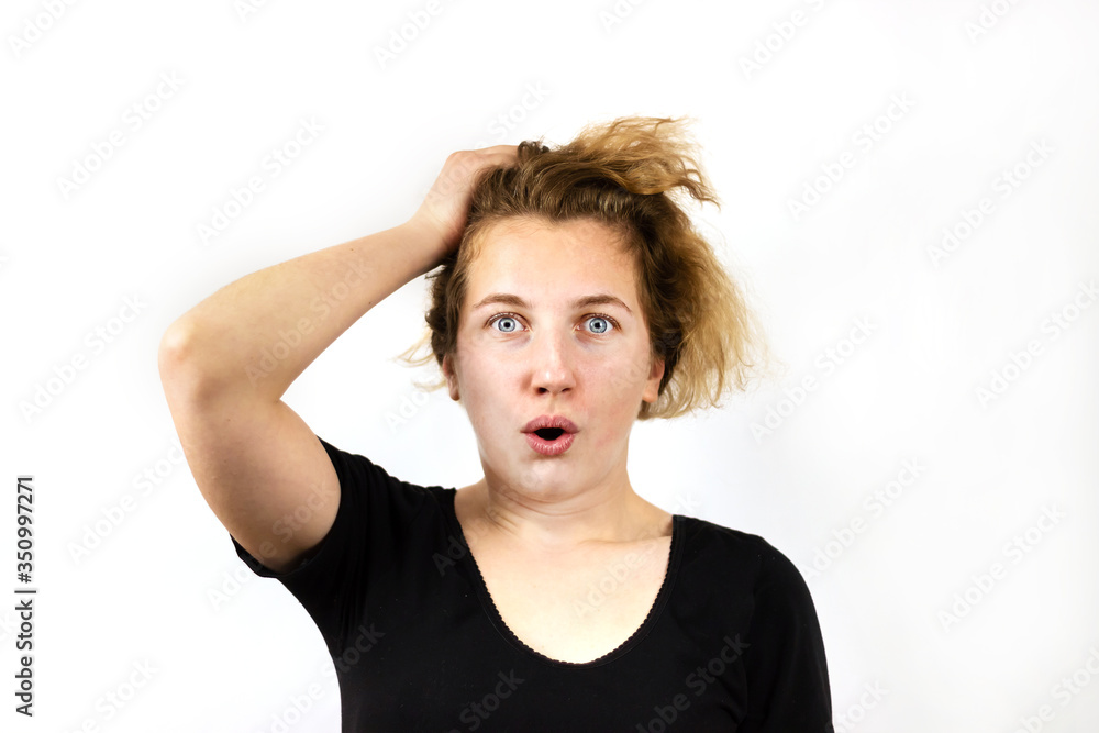 Close-up of a girl with an emotion of surprise with wide-open bright gray eyes, open mouth and raised hands, on a white background. The concept of emotions. Close-up of a girl with an emotion of surprise with wide-open bright gray eyes, open mouth and raised hands, on a white background. The concept of emotions.