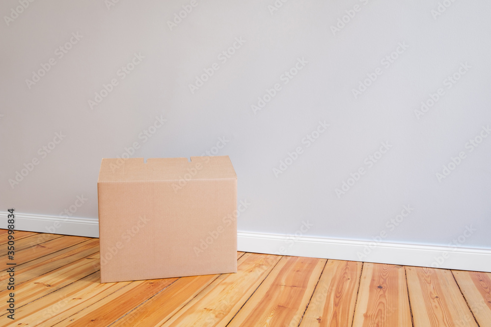 cardboard box on wooden floor in empty room,relocation concept - cardboard box on wooden floor in empty room,relocation concept -
