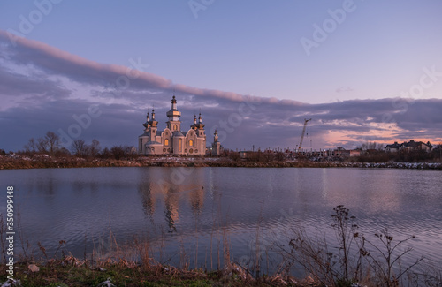 Sokilnyky, Lviv, Ukraine, Pustomyty district. Lake and church at sunset. April 2020