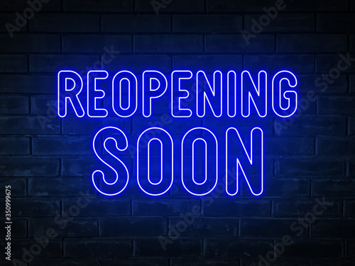 Reopening soon  - blue neon light word on brick wall background	
 photo