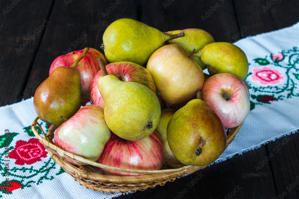 Apples and pears in a basket and honey on a black background. Apples and pears in a basket and honey on a black background.