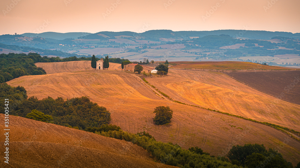 Beautiful warm toned sunset over Val d'Orcia at pink hour. Tuscany, Italy