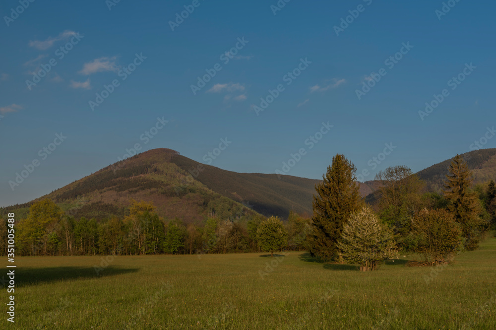 Hills over Trojanovice village in spring sunny color evening