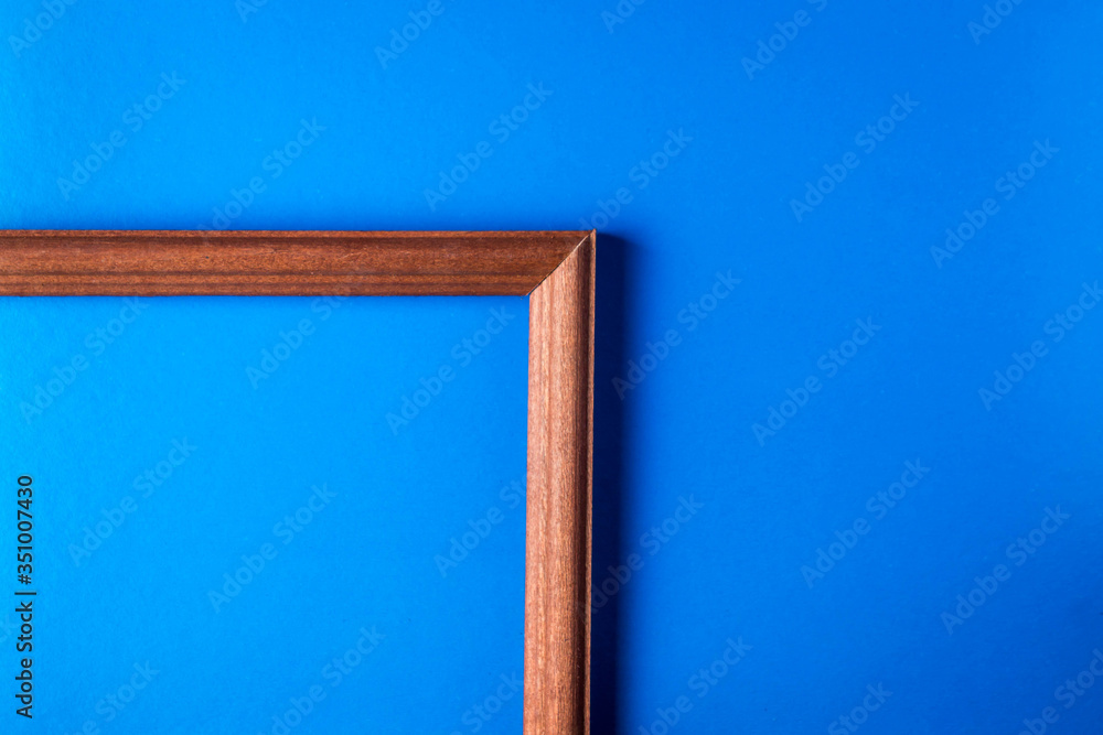 Wooden frame on a blue background. The frame is in the lower left corner. empty space for an inscription.
Wooden frame on a blue background. The frame is in the lower left corner. empty space for an inscription.