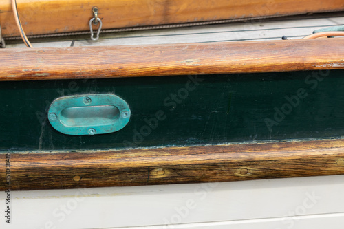 Details on an old wooden ship, hawsehole with green patina, creative copy space, horizontal aspect photo