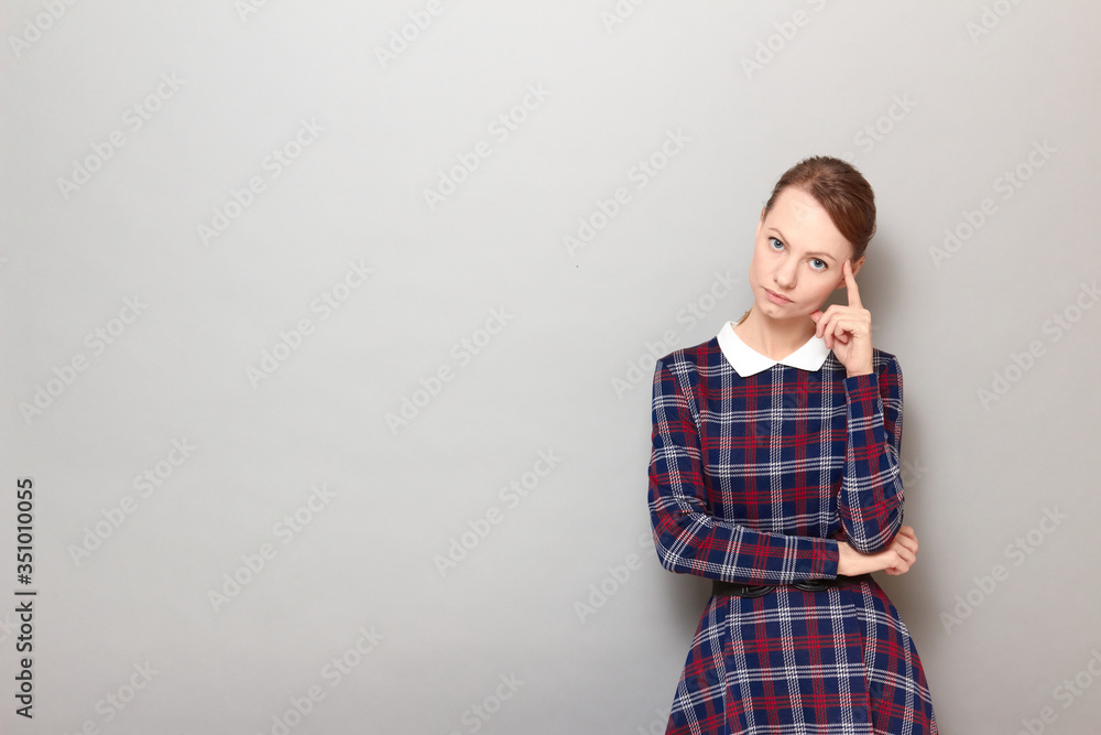 Portrait of serious focused girl touching temple with finger Portrait of serious focused girl touching temple with finger