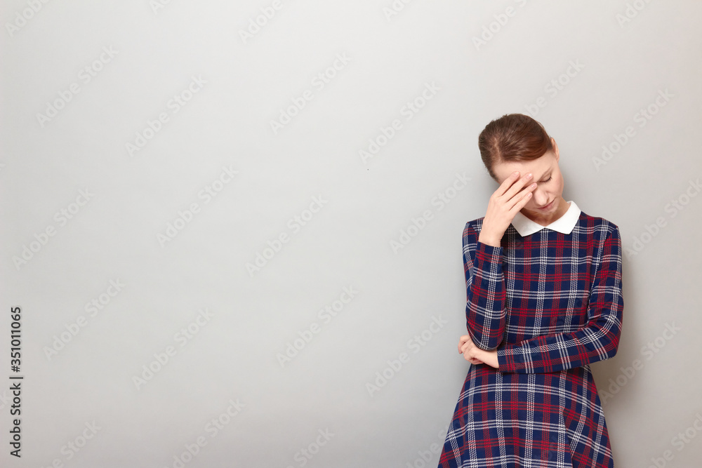 Portrait of girl touching forehead with hand and tilting head down Portrait of girl touching forehead with hand and tilting head down