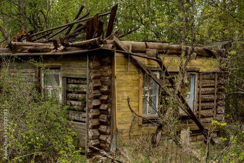 Obraz na płótnie Destroyed wooden old houses in an abandoned village evicted during the Chernobyl accident at a nuclear power plant. Ukraine. w salonie