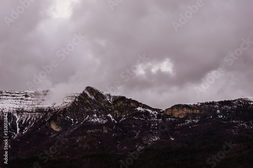 A picturesque landscape view of the high snow capped Alps mountains on a gloomy winter day (Gap, Hautes-Alpes, France)