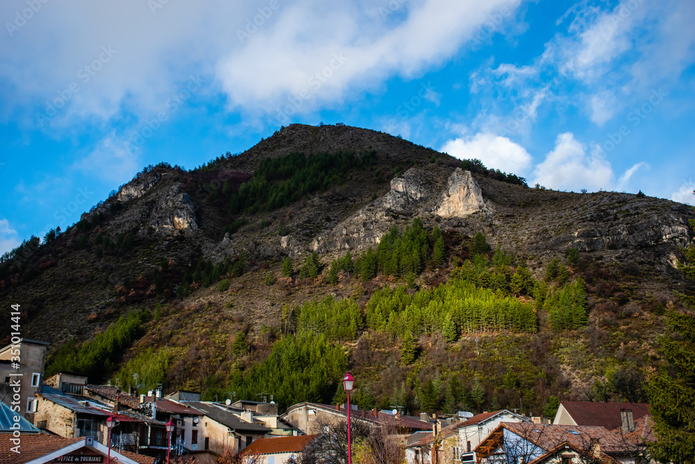 A picturesque view of an old French town in the Alps at the bottom of an alpine cliff's peak (Veynes, Hautes-Alpes, France)