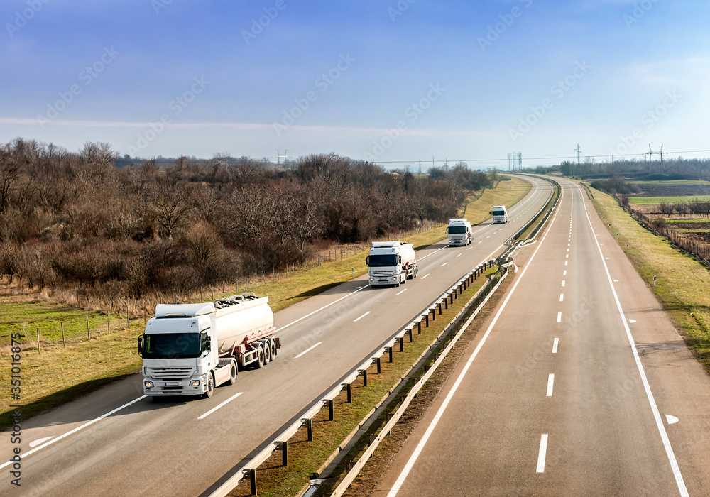 Convoy or Fleet of Tank trucks on a winding Highway through the rural landscape