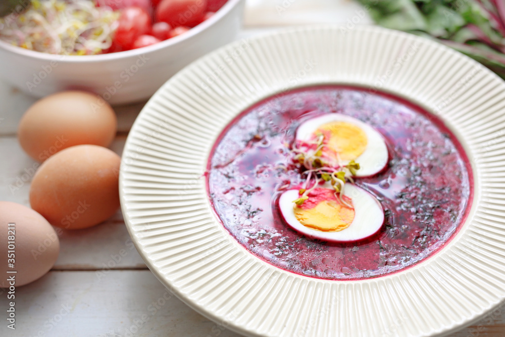 Beetroot soup with egg, traditional spring soup.
Plate of tasty healthy soup on a wooden table. Vegetable cuisine